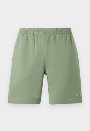 Groene katoenen shorts met een elastische tailleband, ontspannen pasvorm en een klein geborduurd logo aan de onderkant aan de linkerzijde. Gladde textuur, geen zakken.