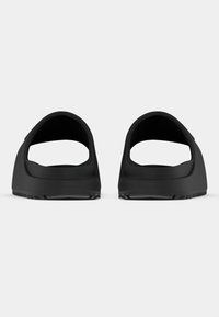 Czarne sandały z odkrytą piętą, posiadające gładką teksturę, zaokrąglony kształt oraz gumową podeszwę z rowkami zapewniającymi przyczepność.