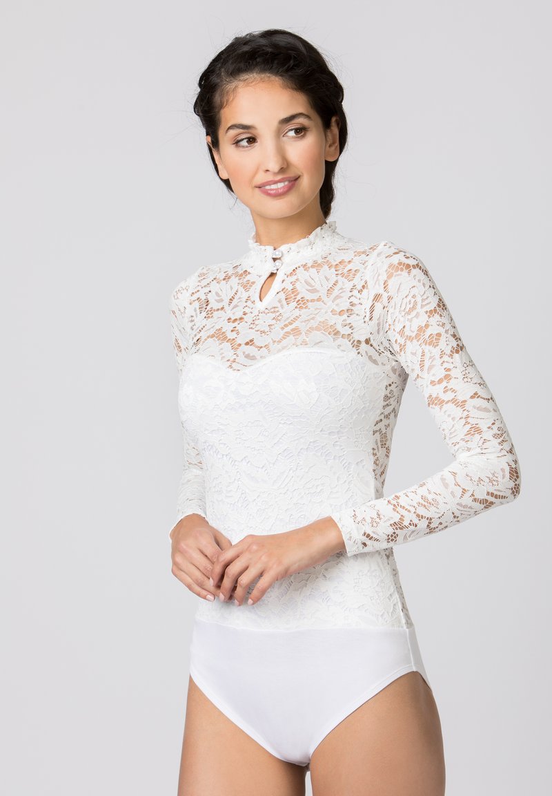 Weißer Spitzen-Bodysuit mit langen Ärmeln, durchsichtigem Blumenmuster, hohem Kragen mit einem Schlüssel-Loch-Detail und einem festen weißen unteren Teil.