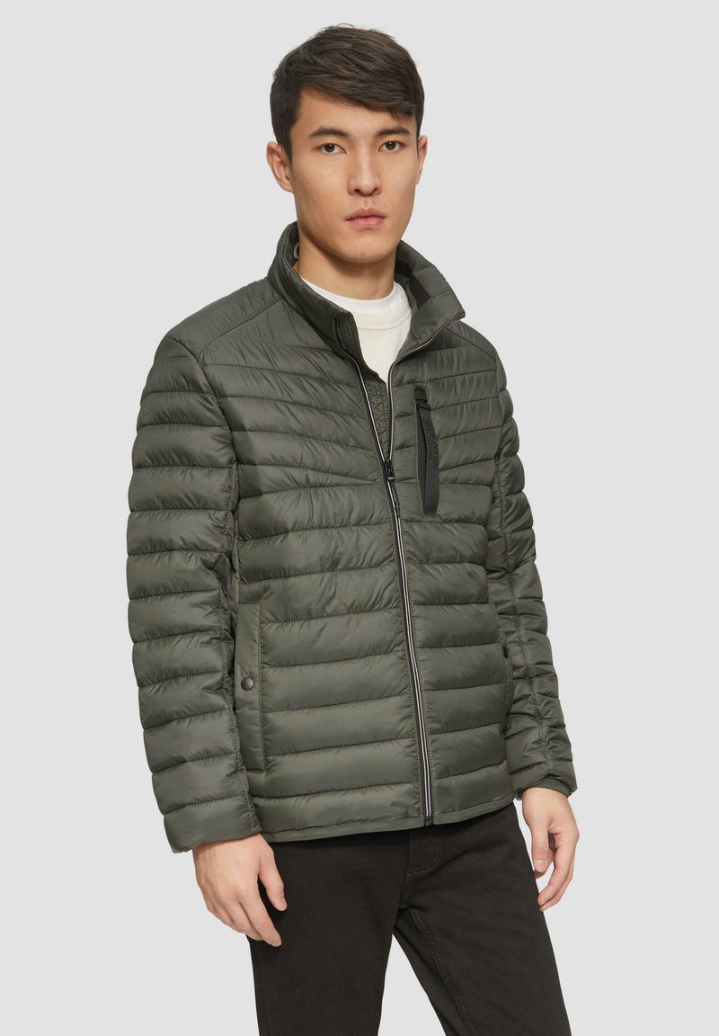 Grüne Pufferjacke mit vertikal gestepptem Design, Stehkragen, Reißverschluss vorne und mit Reißverschluss versehenen Brusttasche. Glatte Oberfläche und leicht.
