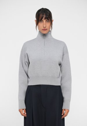 Pull gris zippé avec un col montant et un design court, fabriqué en matériau doux. Présente des épaules tombantes et une finition côtelée.