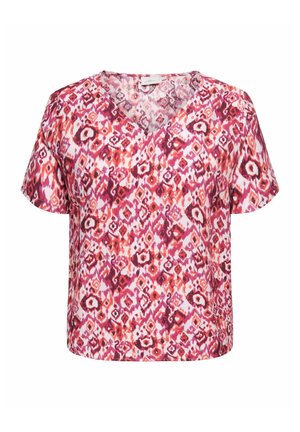 Blusa a maniche corte con scollo a V, con vivace motivo geometrico astratto in rosso, rosa e viola su sfondo bianco.