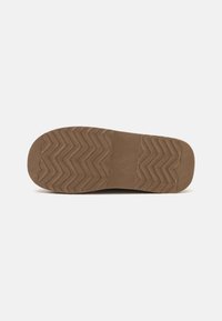 Talpa de pantof maro cu un model de uzură în zigzag. Fabricată din cauciuc, având o suprafață texturată și o secțiune centrală netedă.