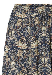 Floral-patterned fabric skirt in dark blue, featuring elastic waistband, intricate floral and vine motifs in cream, orange, and green.