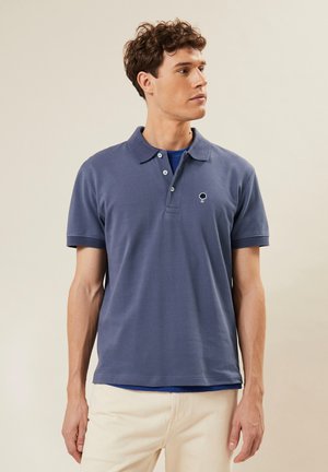 Donkerblauwe polo shirt van katoen, met een klassieke kraag, een drieknopenpad en een klein boomlogo op de borst.