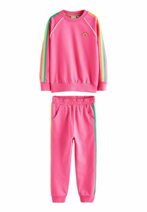 Roze sweatshirt en broek set gemaakt van zacht materiaal. De sweatshirt heeft een klein regenboogontwerp; de broek heeft zijzakken en kleurrijke strepen.