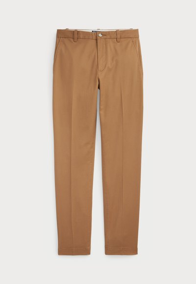 Brune bomullsbukser med en slim-fit design, flat front og standard lommer; jevn tekstur og kantede mansjetter.