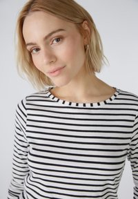 Zwart-wit gestreepte top met een ronde hals, gemaakt van lichtgewicht stof. Heeft lange mouwen en een zachte textuur.