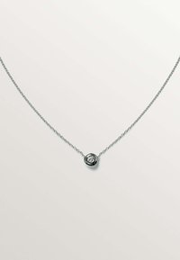 Collar de cadena de plata con un colgante circular que presenta una piedra preciosa transparente en el centro, exhibiendo un acabado pulido y un diseño de eslabones delicado.