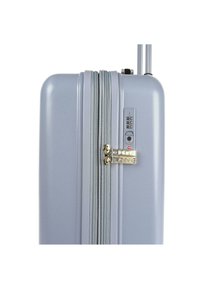 Maleta rígida en gris claro, con una superficie texturizada, herrajes de cremallera dorados, candado de combinación y asa extensible.