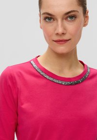 Fuchsia langdunkt shirt met een ronde halslijn versierd met een textuur van metallic zilver. Soepele stof met een relaxte pasvorm.