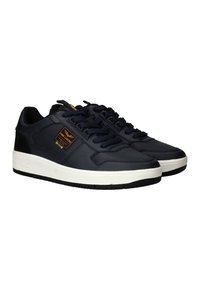 Marineblauwe sneakers van glad leer, met een dikke witte zool, textuurdetails en zwarte accenten op de hiel en de tong.