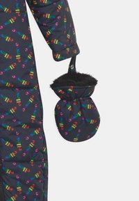Zwarte pufferjas met een kleurrijk "ellesse" logo-patroon, met afneembare wanten gevoerd met bont voor extra warmte.