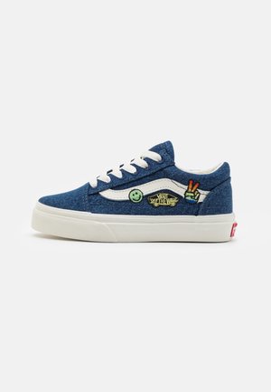 Blauwe denim sneakers met witte stiksels, ronde veters en kleurrijke geborduurde patches met een glimlachende gezicht en een vredessymbool. Witte rubberen zool.