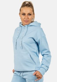 Felpa blu chiaro realizzata in tessuto morbido. Presenta un cappuccio con cordino, tasca a marsupio e polsini a costina. Texture liscia con accento del logo.