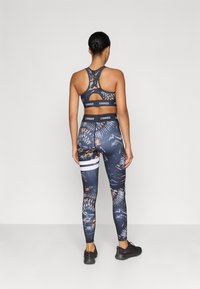 Athletic set with a navy base, featuring floral patterns. The sports bra has a racerback design, while leggings have a side stripe detail.