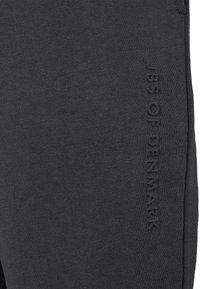 Mørkegrå sweatpants lavet af blød stof. Har et fordybet, struktureret print med teksten "JBS OF DENMARK" på benet. Minimalistisk design.