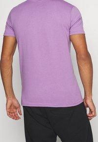 Lila kortärmad T-shirt med rund halsringning, mjuk textur och figurnära passform. Har en ren finish vid fållen och ärmarna.