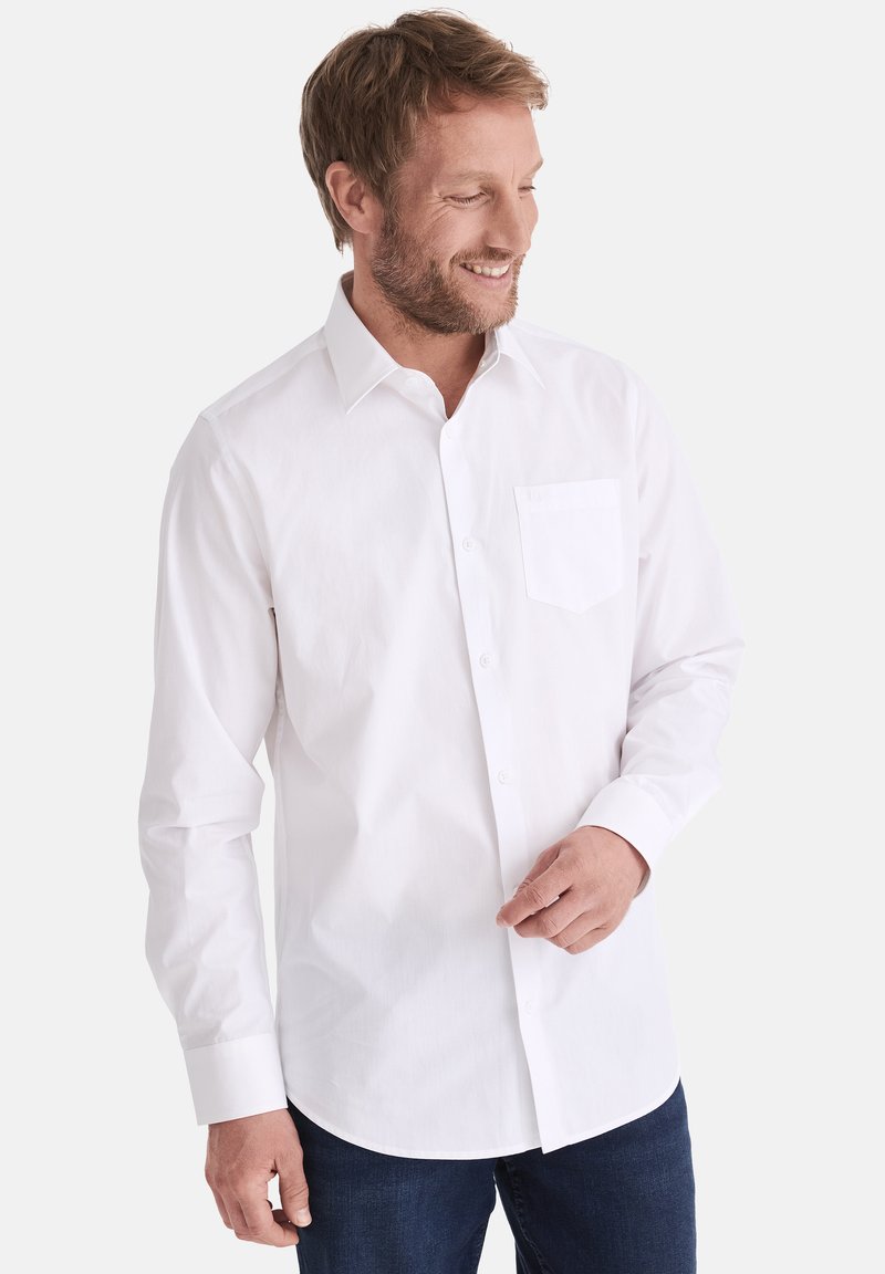 Weißes Langarmhemd mit klassischem Kragen, Frontknopfverschluss und einer einzelnen Brusttasche, kombiniert mit dunklen Jeans. Einheitliche Textur.