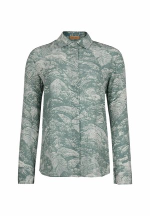Langærmet skjorte med knapper, prydet med grønne og hvide tropiske bladmønstre og klassisk krave på en ensfarvet hvid baggrund.