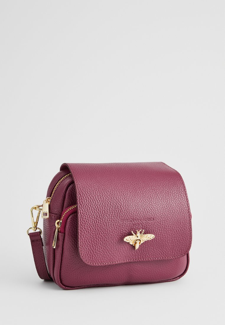 Bolso de hombro de cuero púrpura con un acabado texturizado, que presenta un acento de abeja dorada en la tapa y un compartimento con cremallera.