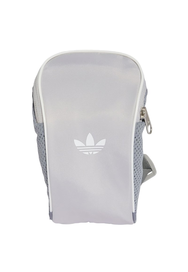 Zaino grigio con una parte anteriore liscia, lato in rete, cerniera bianca e un sottile logo bianco. Ha un design moderno e una forma aerodinamica.