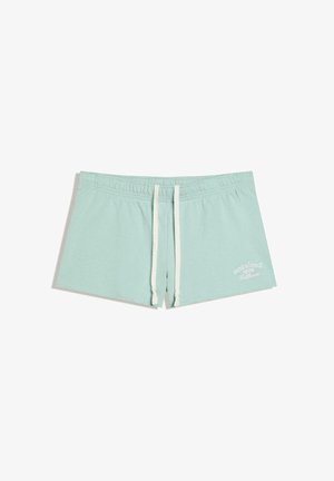 Shorts de bain bleu clair avec cordons blancs et texte "Venice Beach 1985 California" sur le côté inférieur droit.