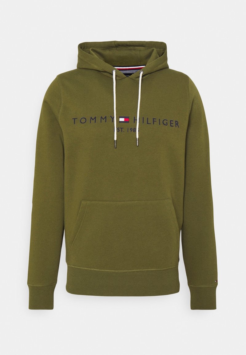 Olive green hoodie with front pocket, white drawstrings, and "Tommy Hilfiger Est. 1985" logo across the chest with a small flag emblem.