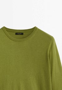 Pull col rond vert olive avec texture en maille fine et col côtelé, posé à plat sur un fond blanc.