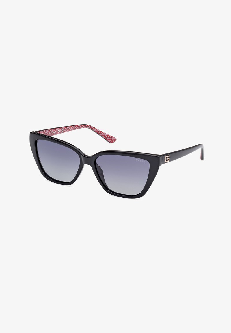 Black cat-eye sunglasses with gradient lenses. Red patterned temple arms and gold logo detail on side. Texture is smooth and glossy.