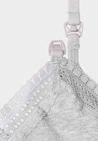Szürke melltartó csipkés szegéllyel, állítható pántokkal és műanyag kiegészítőkkel. Texturált anyag, bordázott mintával az alsó részen.