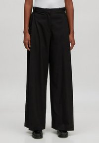 Zwarte wijde pantalons met een platte voorkant, hoge taille en plooidetails, gemaakt van een gladde stof, met zijzakken en riemlussen.