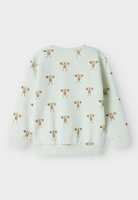 Hele rohelise värvi laste kapuutsiga sviiter, millel on kõikjal trükk karikaturistidest tugevatest meestest, kes tõstavad kaalu pruuni jaoranži triipudega.