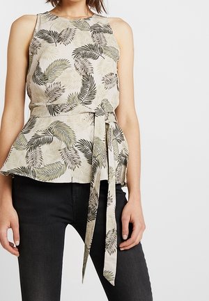 Bloemenprint peplum top met groene en beige bladpatronen, lichtgewicht stof, mouwloos, taille detail met strik, gecombineerd met donkere spijkerbroek.