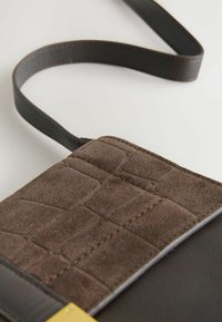 Brun læder crossbody taske med en tekstureret ruskindsklap med krokodillemønster, guldtonet metaldele og en matchende rem.