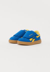Zapatos infantiles en azul y amarillo, hechos de material de ante, con una correa de Velcro, cuello acolchado y una suela de goma para mayor tracción.