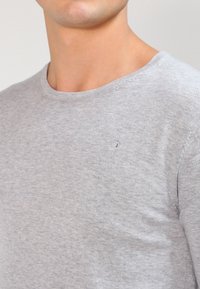 Grijze crew neck t-shirt van zacht katoen, met een subtiele logodetail op de borst en een gladde textuur.