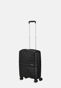 Valigia rigida nera con un design a chevron texturizzato, manico estensibile e quattro ruote girevoli per una facile mobilità. Chiusura con zip.