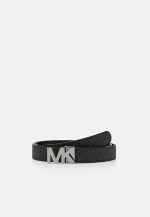 Ceinture de créateur noire avec motif « MK » répété et boucle « MK » en argent poli, roulée à plat sur fond blanc.