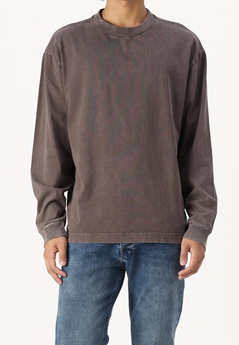 Tričko s dlouhým rukávem a kulatým výstřihem v tlumené hnědé barvě. Vyrobeno z měkké, strukturované tkaniny s volným střihem. Dekorativní prošití podél lemu.