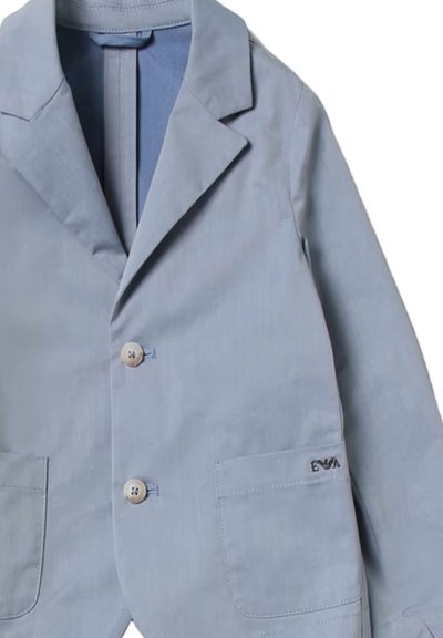 Blazer azzurro chiaro in un tessuto liscio, con due tasche frontali, colletto a risvolto e bottoni in legno. Marchio discreto sulla tasca.