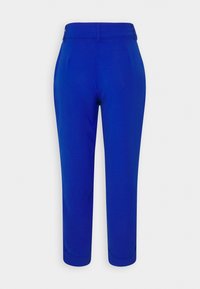 Pantalon court bleu sur mesure avec passants de ceinture et revers relevés, présenté sur fond blanc.