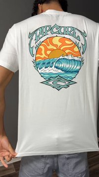 Άτομο που φοράει λευκό T-shirt με πολύχρωμο γραφικό ήλιο και κύμα ωκεανού και το κείμενο "Rip Curl" στην πλάτη.