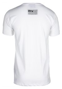 Camiseta blanca de algodón con cuello redondo y mangas cortas, con una etiqueta negra en la parte posterior que muestra información de la marca e instrucciones de cuidado.