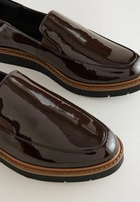 Scarpe slip-on in pelle verniciata marrone con finitura lucida, pannelli elastici laterali, cuciture a contrasto e suola nera spessa.