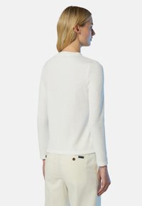 Maglione bianco a maniche lunghe con scollatura rotonda, realizzato in un materiale morbido; design minimalista con una silhouette aderente.
