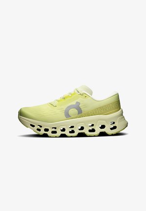 Chaussure de course jaune clair avec semelle à motif alvéolé, fermeture à lacets et logo réfléchissant sur le côté, conçue pour un usage sportif.