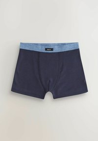 Marineblaue Baumwollboxershorts mit einem hellblauen elastischen Bund. In der Mitte vorne befindet sich ein Etikett. Die Nähte sind entlang der Kanten sichtbar.