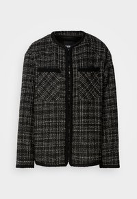Veste en tweed noir et blanc à manches longues, col rond, poches avant et motif à carreaux texturé.