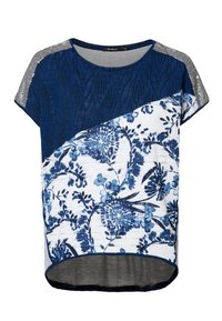 Short-sleeve top featuring a navy blue textured upper, floral patterned lower in blue and white, and gray accents on the shoulders.